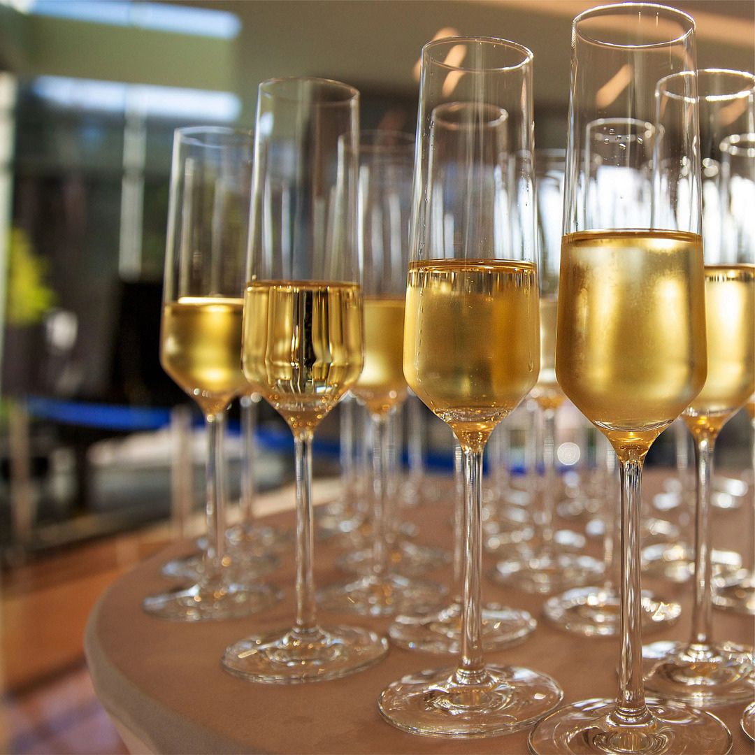 Rows of filled champagne glasses ready for a celebratory toast at a corporate mixer.