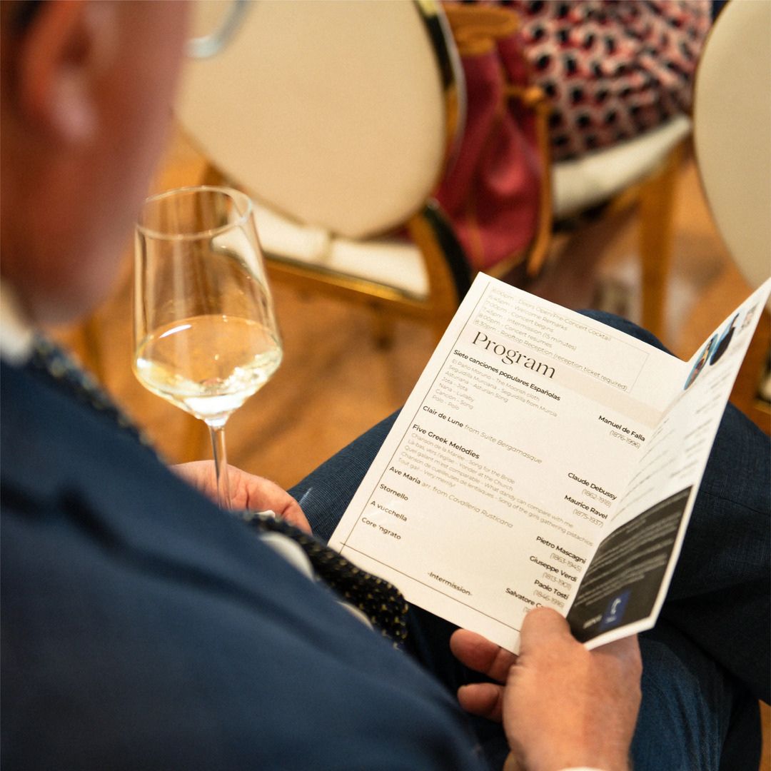 Guest closely reviewing the printed event program during a private gathering at Museo Institute for Medical Arts.