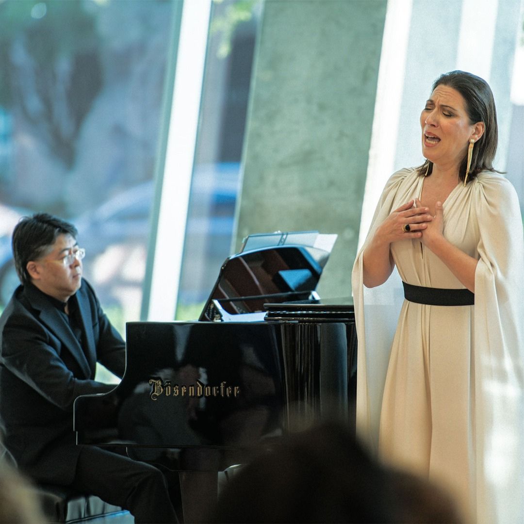 Live performance in the Museo atrium, featuring a pianist and singer bathed in natural light.