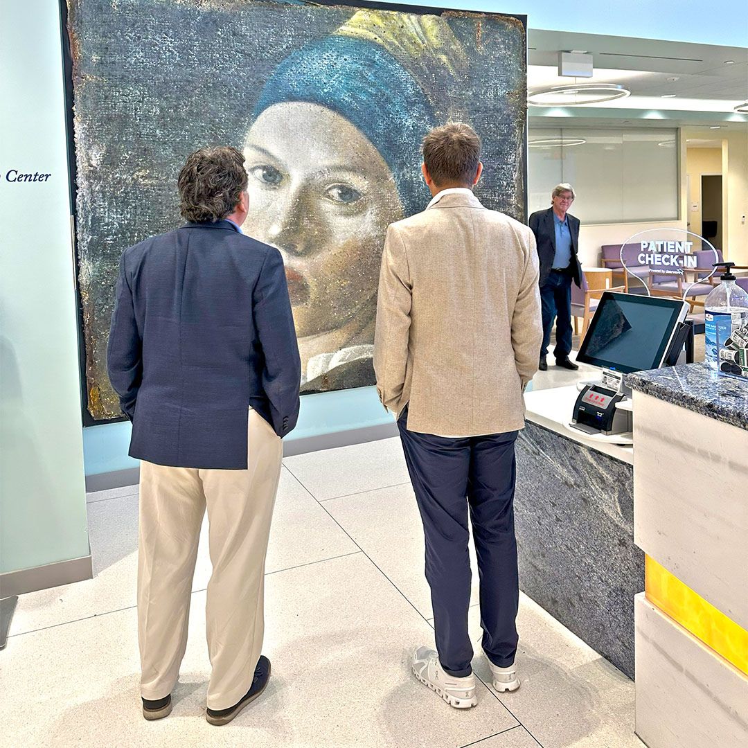 Guests admiring a large-scale contemporary painting, highlighting the integration of fine art within the Museo Houston facility.