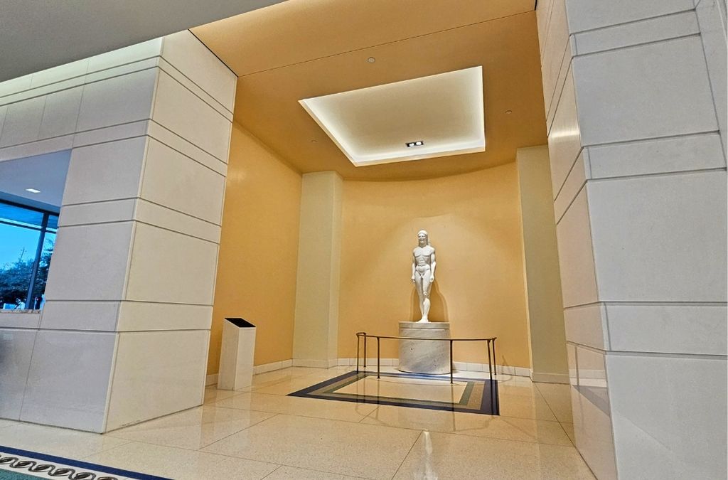 Elegant and bright hallway inside Museo Houston leading to a classical marble statue display.