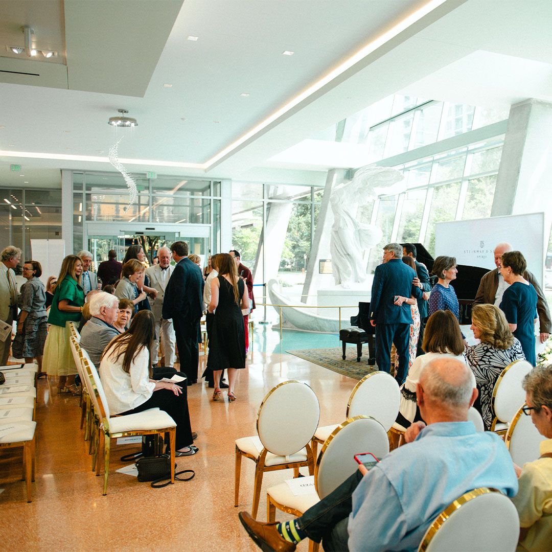 Wide view of the Museo Houston event space filled with natural light and guests.