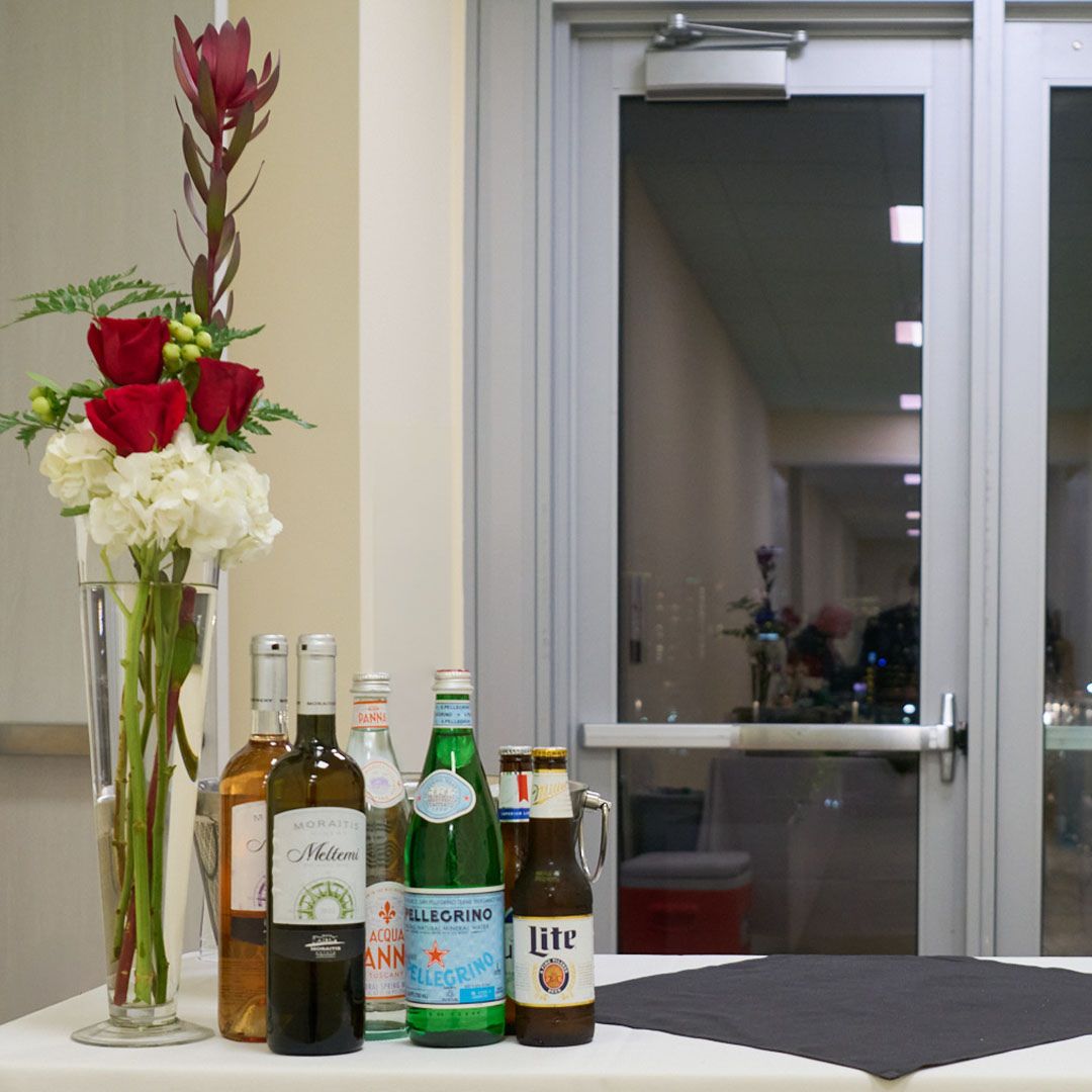 Elegant floral arrangements alongside premium bottled water and beverages for event guests at Museo.