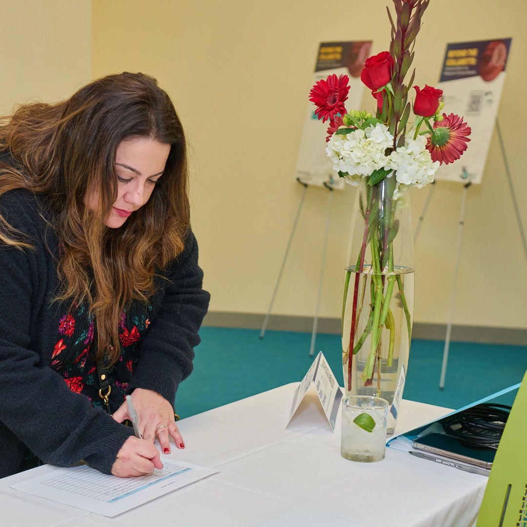 An attendee signing in at the welcome desk during a professional gathering at Museo Houston.