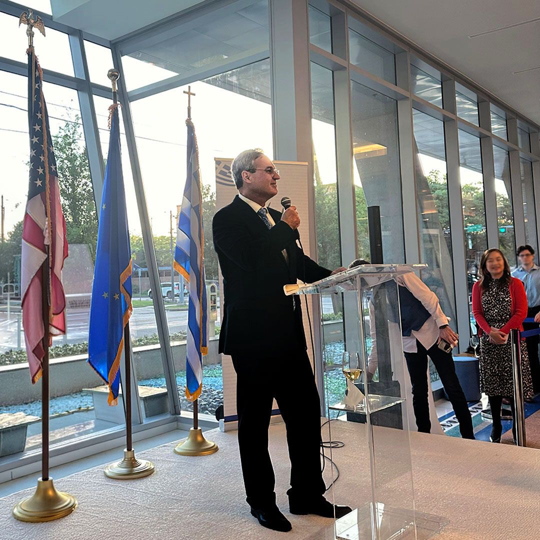 A professional keynote speaker addressing the audience from a podium at a Museo Houston gathering.