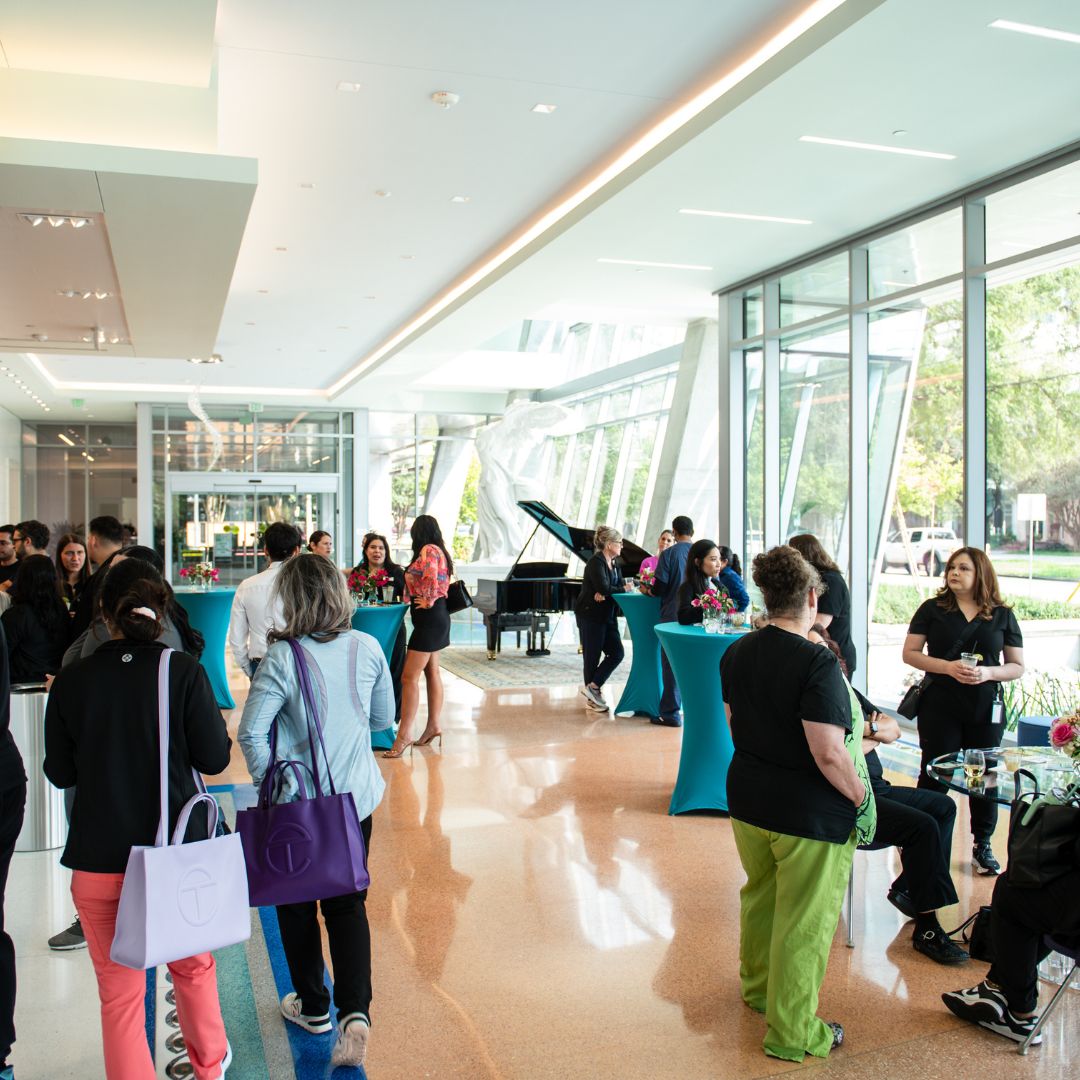 Guests mingling and enjoying refreshments in the spacious, modern lobby during a previous gathering at Museo Houston.