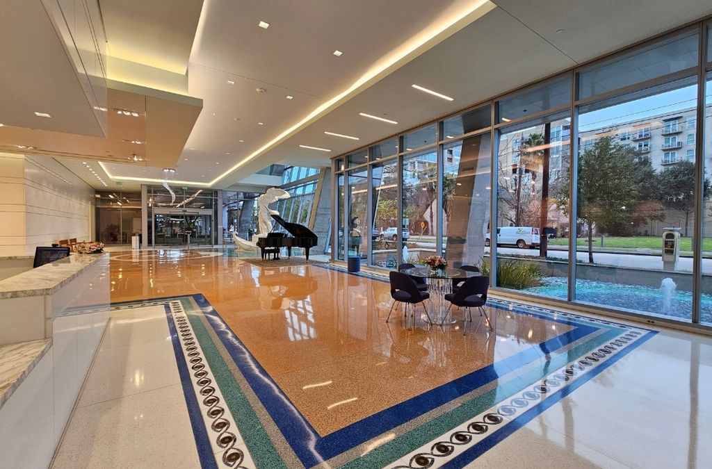 Elegant main lobby of Museo Houston featuring the Winged Victory statue, an indoor water feature, and a grand piano.