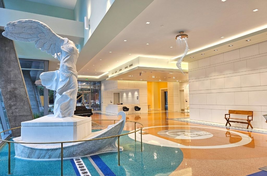 Luxurious interior lobby at Museo Houston featuring a classical white marble statue and a modern indoor water feature.
