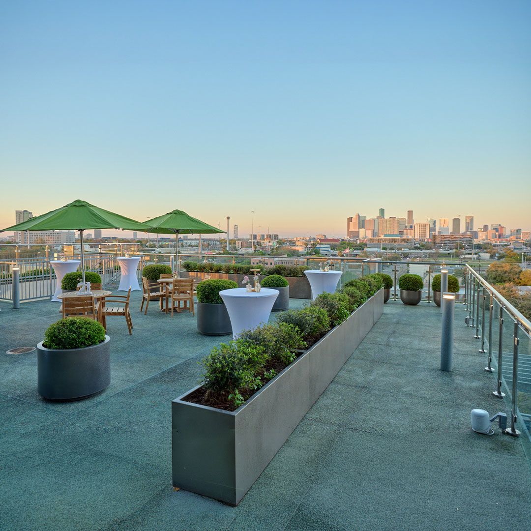 Lush greenery and modern planters along the outdoor walkway of the Museo Houston rooftop event space.