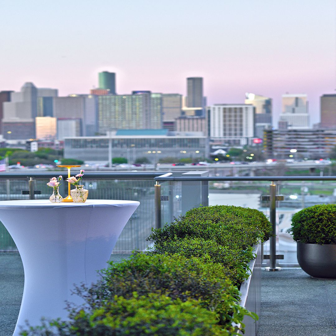 A sleek white cocktail table positioned against the impressive Houston skyline on the Museo terrace.