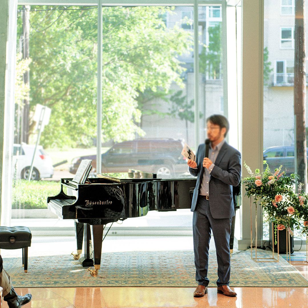 A professional presentation taking place next to a grand piano at Museo Houston.