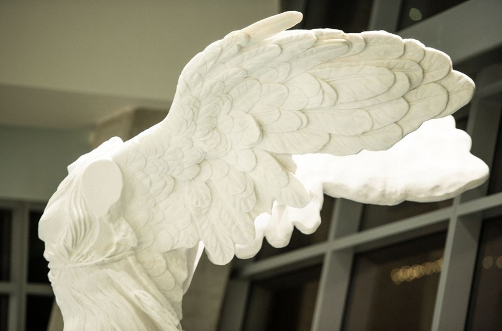 Close-up detail of the carved marble wings on the classical Winged Victory statue at Museo Houston.