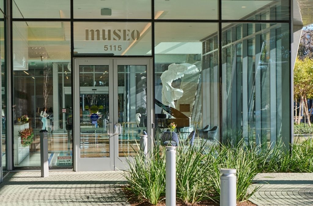 Exterior view of the main glass entrance and signage of the Museo Institute for Medical Arts in Houston.