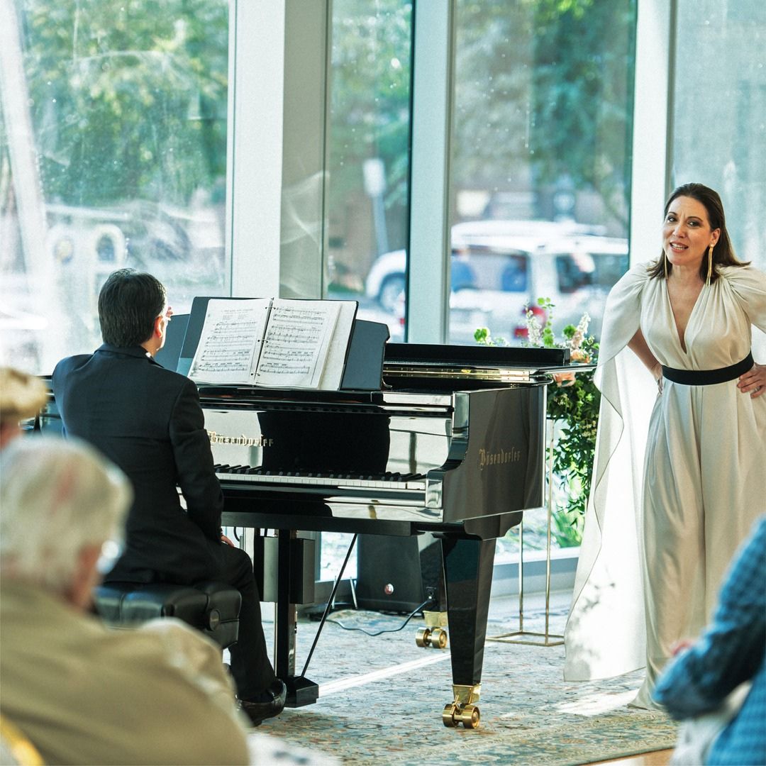 A vocalist and pianist performing for seated guests during an elegant daytime event.